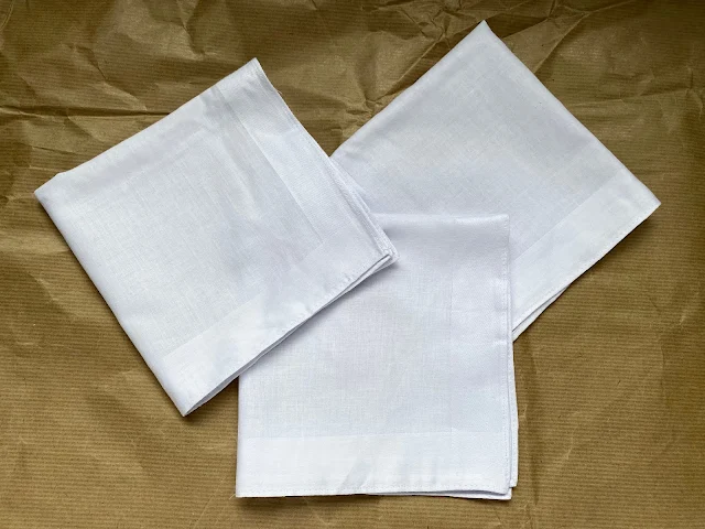 3 white cotton handkerchiefs folded into squares