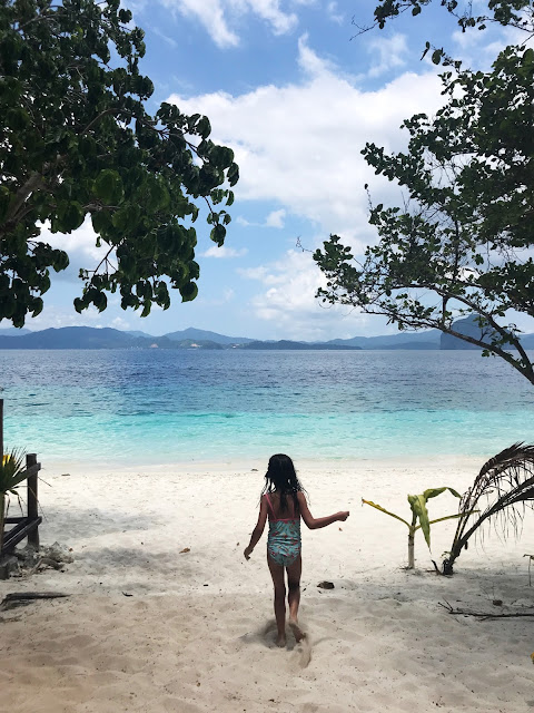 Niña corriendo hacia el mar en Entalula island, El Nido