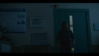 Screenshot from Awake 2021, showing room with posters on right, as Gina Rodriguez opens door.