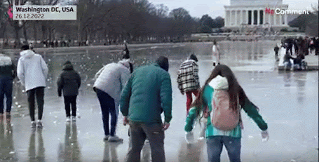 des personnes qui s’amusent sur le miroir d’eau du Lincoln Memorial qui a été complètement gelé