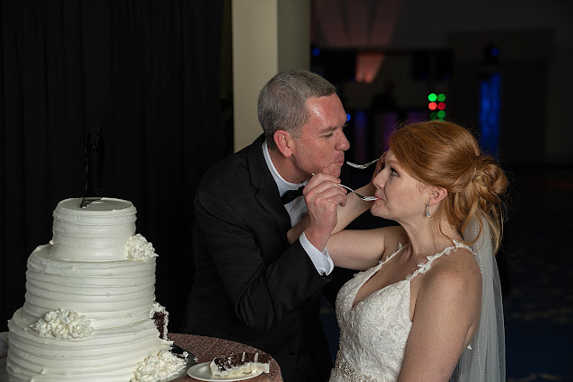 Bride and Groom exchanging a bite of wedding cake Port Saint Lucie Civic Center Wedding Photos by Stuart Wedding Photographer Heather Houghton Photography