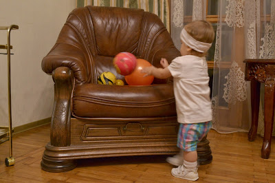 a small girl is playing with balls