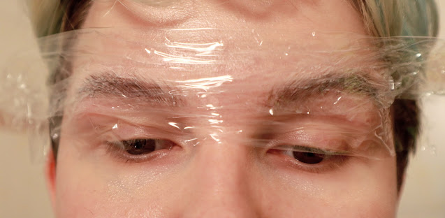 A photo of eyebrows with cream neutralizer on, covered with transparent film