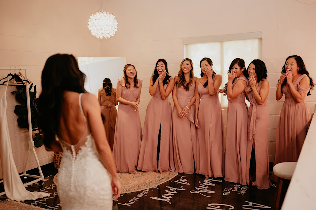 bridesmaids in pink dresses first look with bride
