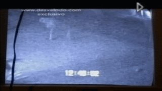 Video of black and white CCTV footage of what appears to be flowing white pants walking across a field
