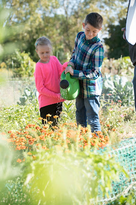 Girl and boy watering flowers