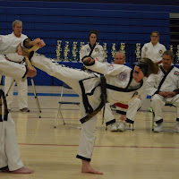 A karate girl kicking a board while blindfolded