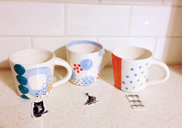 ceramic mugs with decals laid out in front
