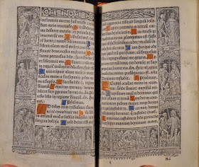 An open page of printed text with decorated initials. There is a printed ornamental border around the text.