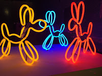 Pic of yellow, blue and red neon lights shaped as dogs 