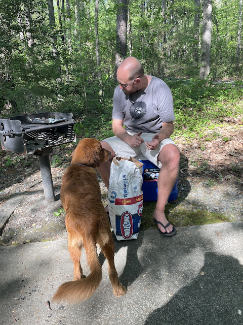 Dad sitting on a cooler with charcoal next to him trying to light a grill at Latta Park on his birthday.