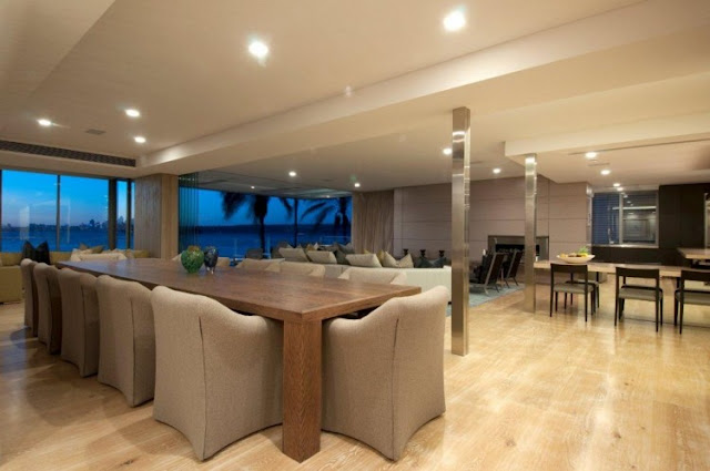 Photo of two large dinning tables and living room in the background 