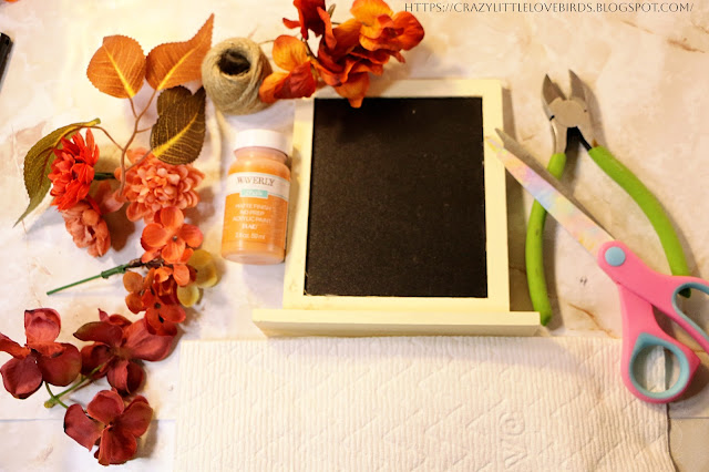Materials such as faux fall leaves, floral, framed chalkboard, and floral cutters