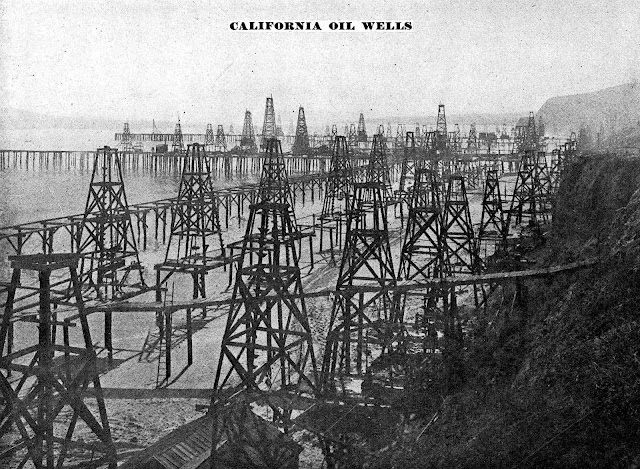 black oil wells on the beach in 1905 California, a photograph
