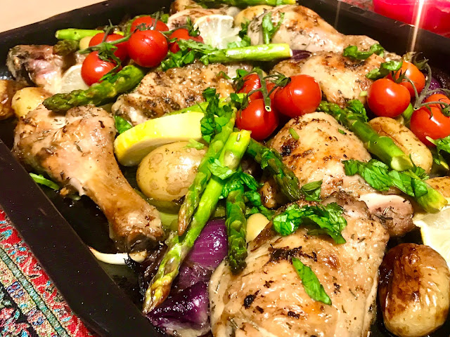 Greek chicken tray bake with asparagus, tomatoes, potatoes and red onion