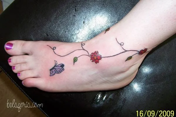 Tatuajes de flores y mariposas en el pie de una mujer