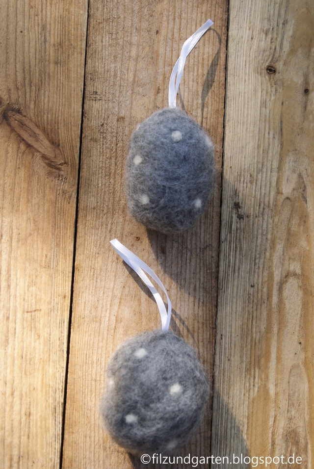 Ostereier mit grauer Wolle und weißen Punkten trockengefilzt