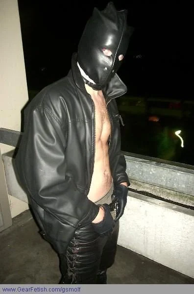Sexy Leatherman wearing black leather car coat and Hood outside