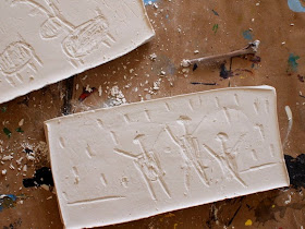 Carve plaster of paris like a rock with a twig