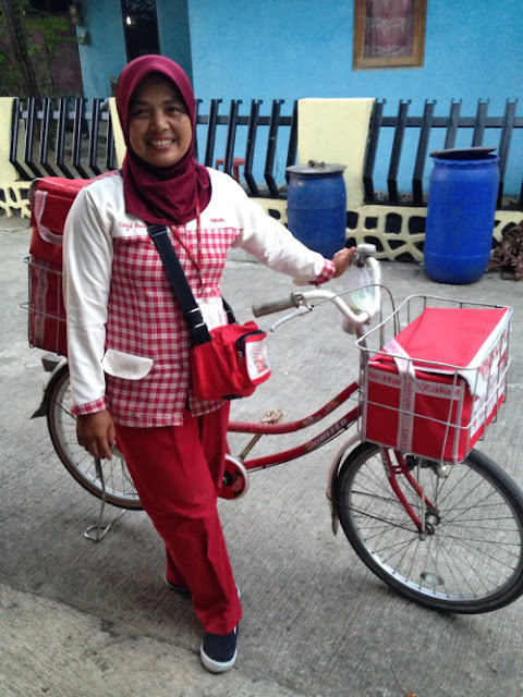  berjalan kaki atau naik sepeda sedang berkeliling komplek menawarkan Yakult Yakult Lady, CSR Cerdas Yakult