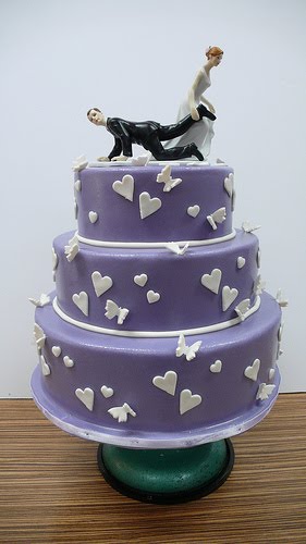 Purple wedding cake over three tiers with heart and white butterflies 