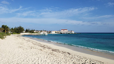 View of beach and sea with condos in the distance.