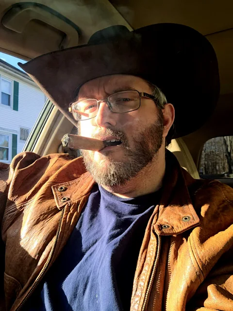 Handsome Cowboys smoking a cigars sitting in a car wearing orange leather jacket