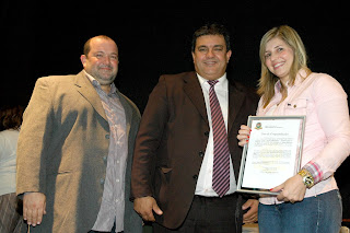  Márcio Catão e Vereador Mandinho com a Primeira-dama Alessandra Rosa em solenidade de homenagem aos trabalhadores e às mulheres