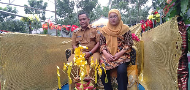 Ahmad Syaiful beserta ibu Diana Putri sedang di upah upah di atas mobil hias