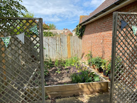 Vegetable patch with trellis entrance and bunting