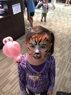 Young girl with face paint and a balloon animal