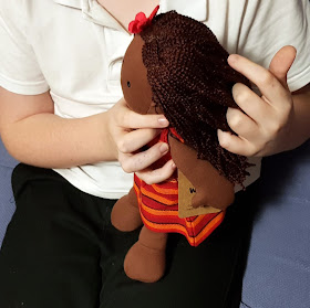 Boy playing with ghanaian multicultural doll