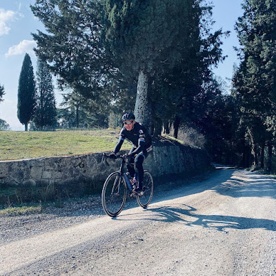 a cyclist enjoy strade bianche gravel trails in Tuscany using a Veloce bicycle rental