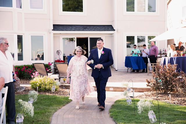 groom walking mother down isle