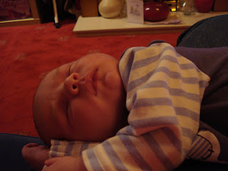 Baby Boy asleep on his side on Mummy's knee