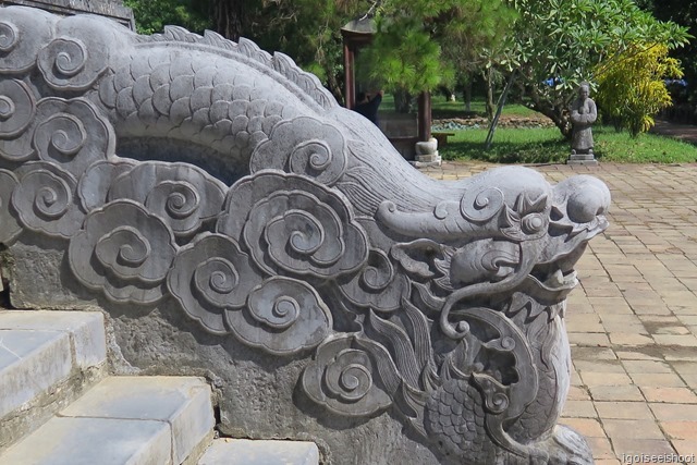 Detailed carved stone dragons flying through clouds decorate the stairs leading up the stele pavilion.at tomb of Minh Mang