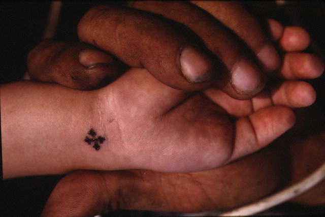 Small cross tattoo on girl wrist and black small cross tattoo on wrist.