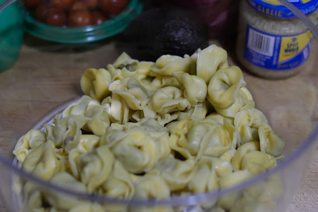 The fully cooked tortellini in a clear bowl.