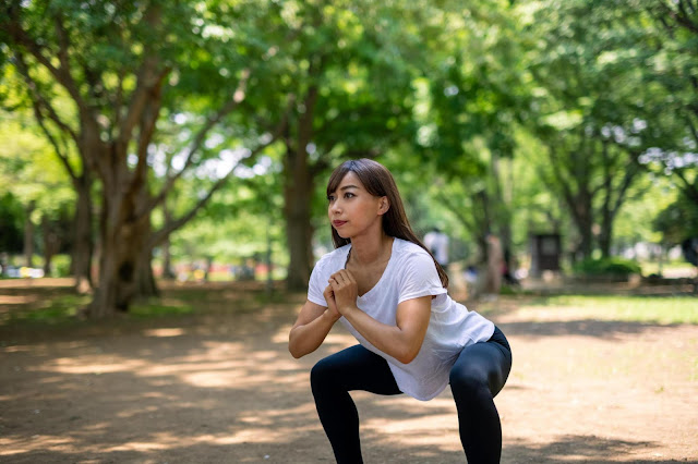 A woman performing a squat exercise, showcasing the benefits of functional strength training for building lean muscle and boosting metabolism.
