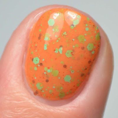 orange nail polish with colorful glitter close up swatch