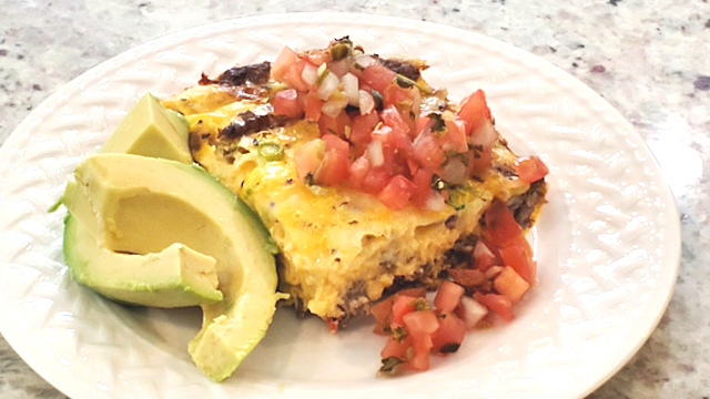 A sausage and egg casserole with avocado and salsa.