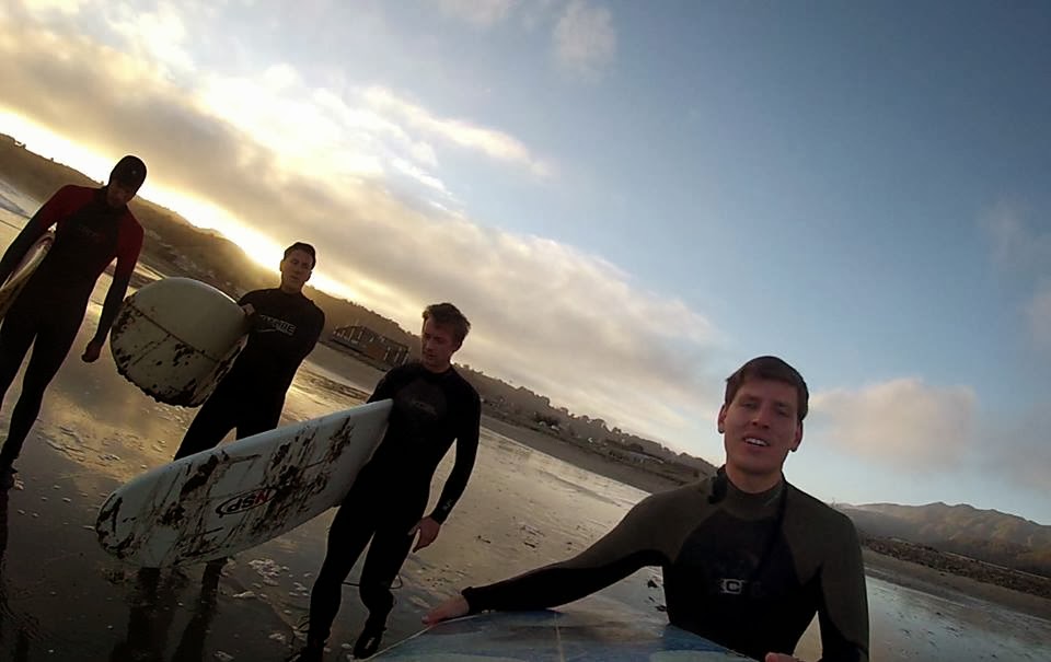 4 guys on the beach about to surf in pacifica