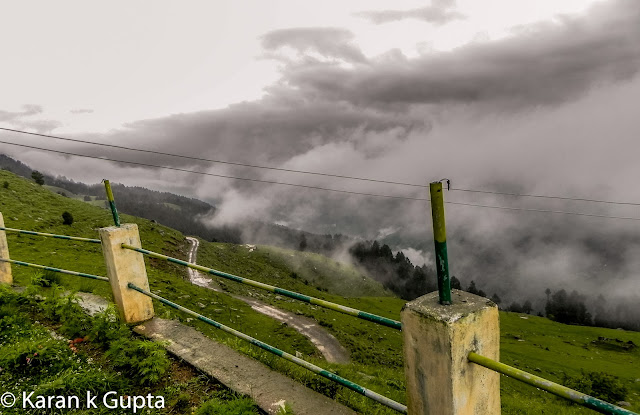 Hello everyone. I may not be good with words but somehow I am going to share about one of the most exciting and memorable trip I had with my family during monsoons of 2012The destination was Prashar lake, situated at a height of 2730 meters above sea level, 49 km north of Mandi, a buzzling town situated in Himachal Pradesh. It’s a place about which very few people know, but once anyone visits Prashar, he longs to come back againFor convenience of visiting tourists, recently HPPWD and HP Forest Department constructed different rest houses. In addition a Trekker’s Lodge was also constructed which is more sophisticated than othersThe bookings can be done from respective offices in MandiAfter making all the necessary arrangements including food etc. , we a group of 15 family members started from Mandi at about 4 pm. It was a risk though in monsoons because almost 25 km of road was a muddy tarmac and had become slippery, thanks to some contractor who didn’t do a good jobAs we came closer to our destination, more the chill in air increased. This was my second visit to Prashar. Earlier I had trekked almost 14 kms to reach there way back in year 2000. The route chosen was via Katindi, Kataula and last thickly populated place en route is Baghi, which is 28 kms from Mandi approximately. Till here the road condition is good. After crossing Baghi you will find lesser number of inhabitants. As you move higher, just 5 km before Prashar you will find one room mud & stone houses, inhabited by shepherds or gaddi’s as they are locally knownWe reached Prashar at 7 pm as last 14 kms of distance had to be covered in fog. The temperature was a whooping 2 degrees celcius in evening. After some tea everyone settled down in quilts and blankets, as that was no doubt the need of hour. With fog and darkness all around there was nothing to be explored nearby, so after a tasteful dinner I sleptI woke at around 6 am in morning. The scenery outside was mesmerizing. It had rained during night. The clouds were making way for mountains to be seen. The cold didn’t stop me from getting my camera and go for a short exploration spree around. The surroundings were full of many types of flowers. The area had various types of flora.At around 8 am it started raining again, and that is when I noticed one of our cars had a flat tyre. It was replaced then and there as chances of heavy rainfall were expected in later part of the day. At such places there are no workshops etc. so one has to come well prepared beforehandOnce all were ready luckily it stopped raining. We all started for the famous Prashar Rishi Temple and Lake. It’s a 15 minute walk from the rest house when you reach and gaze down to see a lake having crystal clear water and a temple premises consisting of three pagoda architecture buildingsThe myth about Prashar Lake is that it was formed after Saint Rishi performed meditation hereThe depth of the lake is still uncertain. Rumors are that the main temple is beneath the lake.  It is also said that there is a big treasure beneath the lake, but no one dares to go and find out. Once some foreign national took a dip in lake to reach the depth.  It is said that once he returned he lost his visionBeing a Sunday the secluded place was abuzz with activity with many tourists thronging to seek blessing and enjoy their SundayOne can make out that how much worshipped diety is Prashar Rishi as large number of followers were seen seeking blessingsThere are two shops which serve delicious rajmah-rice and tea in vicinity of lakeAs the day was foggy, the beauty of Lake was at its bestOne must surely visit the place.
