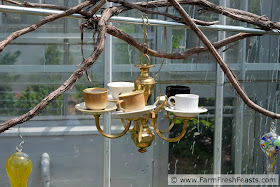 image of an up cycled hummingbird feeder made of a chandelier and teacups in saucers