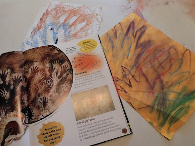 A book and a drawing showing cave paintings of hands