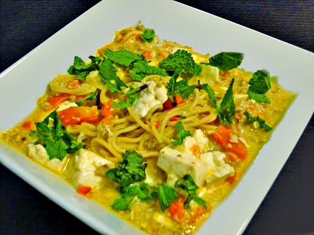 Aromatic broth in square bowl on black place mat