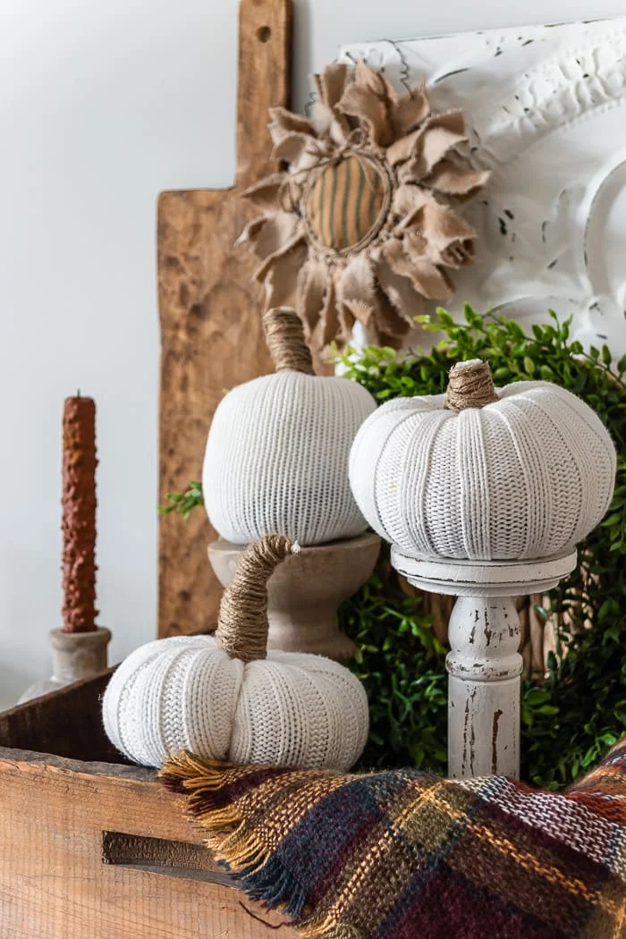 white sweater pumpkins, chunky primitive candle, wood crate, greenery, fall throw