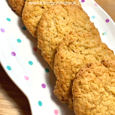 Close up of coconut oat cookies on a spotty plate