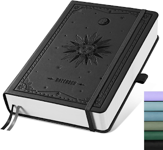 A black leathery thick journal with a sun embossed in the front.