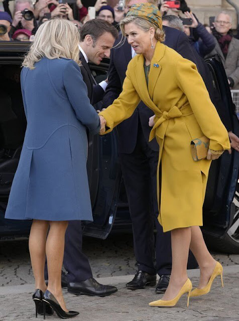 Queen Maxima's outfit is from the fashion house Natan. Brigitte Macron wore a blue coat and dress by Louis Vuitton